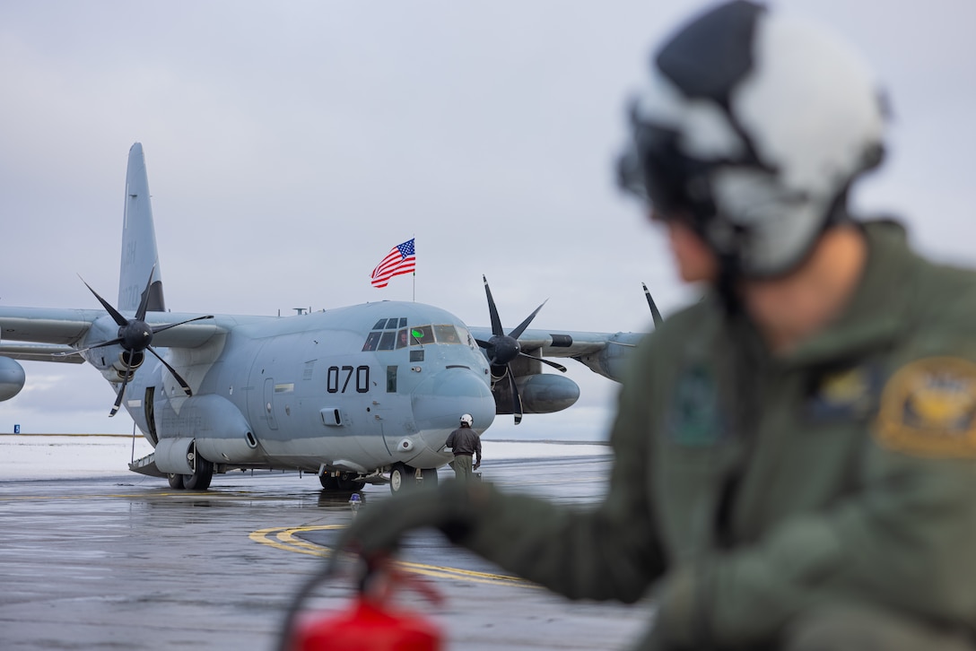 U.S. Marine Corps Cpl. Colby Judge, a native of Connecticut and a KC-130 loadmaster with Marine Aerial Refueler Transport Squadron (VMGR) 252, 2nd Marine Aircraft Wing, observes the flightline in preparation to conduct aviation-delivered ground refueling with Finnish Air Force F/A-18 Hornets during Exercise Nordic Response 24 at Andenes, Norway, March 12, 2024. Exercise Nordic Response is designed to enhance military capabilities and allied cooperation in high-intensity warfighting scenarios under challenging arctic conditions, while providing U.S. Marines unique opportunities to train alongside NATO allies and partners. (U.S. Marine Corps photo by Cpl. Christopher Hernandez)