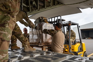 Loadmasters and crew chiefs load bundles of humanitarian aid destined for an airdrop over Gaza.