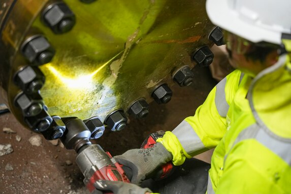 A technician in support of Joint Task Force-Red Hill (JTF-RH) tightens bolts on air gap flanges disconnecting the Underground Pumphouse from the Red Hill Bulk Fuel Storage Facility (RHBFSF), Halawa, Hawaii, March 13, 2024.