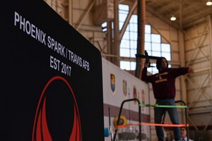 Student throws glider next to Phoenix Spark sign