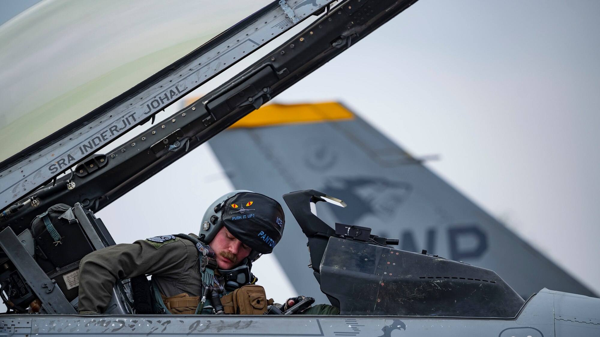 Maj. Gregory Rinker, 35th Fighter Squadron F-16 Fighting Falcon pilot, fastens flight gear before departing for a routine flight