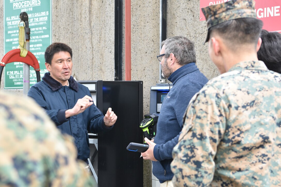 Koji Oba (left), an environmental staff member asks Tim Throckmorton, a Gasboy field engineer, questions about the new payment system during a training session at Combined Arms Training Center, Camp Fuji, March 7, 2024. (U.S. Marine Corps photo by Song Jordan)