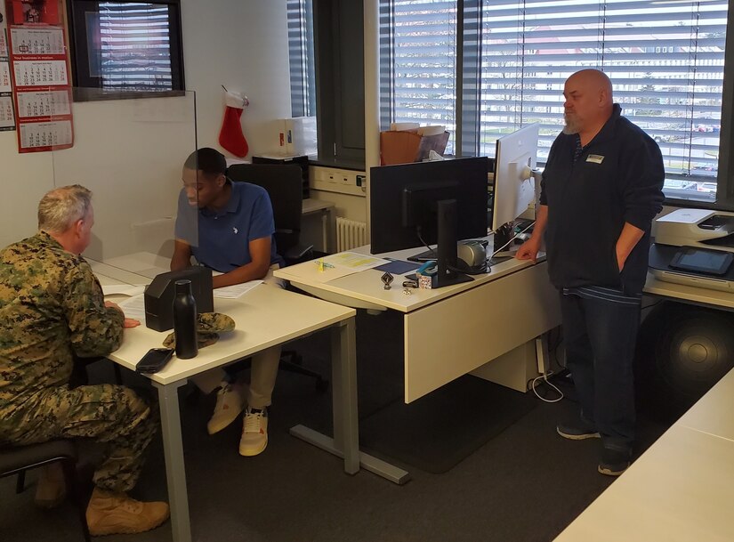 Bill Johnson, the chief of the Personal Property Processing Office at Logistics Readiness Center Stuttgart, (right) observes Trey Bailey, a PPPO transportation assistant, as he assists a Navy captain with his outbound household goods shipment planning. Johnson said peak permanent change of duty station will be starting in about a month, and it’s going to get extremely busy. (U.S. Army courtesy photo)