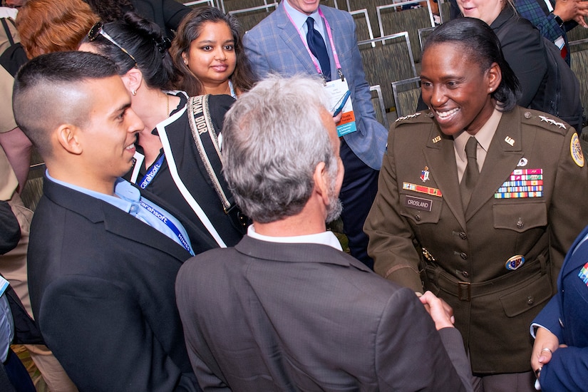 An Army officer shakes hands with a group of civilians.