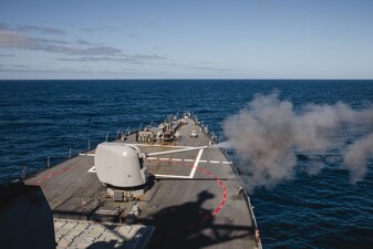 USS John S. McCain (DDG 56) fires its Mark 45 5-inch gun during a live-fire exercise in the Pacific Ocean.