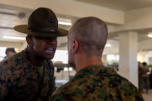 U.S. Marine Corps Sgt. Immanuel Chrisp, a drill instructor with Kilo Company, 3rd Recruit Training Battalion, inspects a recruit during a senior drill instructor inspection at Marine Corps Recruit Depot San Diego, California, March 7, 2024. The SDI Inspection is the first of several inspections recruits will undergo throughout the duration of their training at MCRD San Diego and aims to ensure the recruits are upholding the uniform orders given to them. (U.S. Marine Corps photo by Cpl. Joshua M. Dreher)