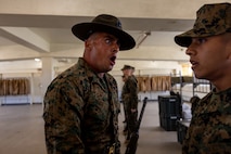 U.S. Marine Corps Staff Sgt. Robert Roach, a drill instructor with Kilo Company, 3rd Recruit Training Battalion, inspects a recruit during a senior drill instructor inspection at Marine Corps Recruit Depot San Diego, California, March 7, 2024. The SDI Inspection is the first of several inspections recruits will undergo throughout the duration of their training at MCRD San Diego and aims to ensure the recruits are upholding the uniform orders given to them. (U.S. Marine Corps photo by Cpl. Joshua M. Dreher)
