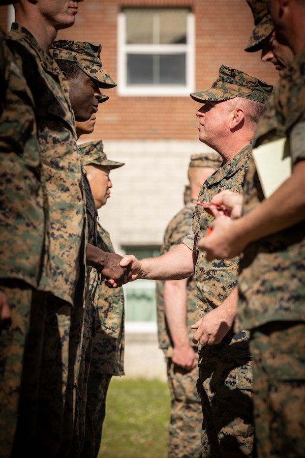 U.S. Marine Corps Master Gunnery Sgt. Jerome W. Bostick, center right, G-3/5 chief with Headquarters Battalion, 4th Marine Division (MARDIV), Marine Forces Reserve, awards Marines with Golf Company, 2nd Battalion, 23rd Marine Regiment, 4th MARDIV Rifle Squad Competition badges and Navy and Marine Corps Achievement Medals during the Awards Ceremony on Marine Corps Base (MCB) Camp Lejeune, North Carolina, March 11, 2024. The three-day event tested the Marines across a variety of infantry skills to determine the most combat effective rifle squad within the 4th MARDIV. MCB Camp Lejeune training facilities allow warfighters to be ready today and prepare for tomorrow’s fight. (U.S. Marine Corps Photo by Cpl. Antonino Mazzamuto)