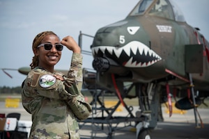 A weapons airman poses in front of an A-10C Thunderbolt II