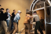 U.S. Marine Corps recruits with Lima Company, 3rd Recruit Training Battalion, are rushed into the receiving building during receiving at Marine Corps Recruit Depot San Diego, California, March 11, 2024. During the receiving process drill instructors are responsible for ensuring recruits are checked for contraband, given haircuts, make a phone call home, and are issued the gear necessary for training. (U.S. Marine Corps photo by Sgt. Yvonna Guyette)