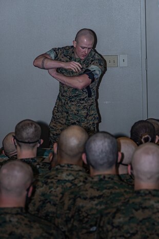 U.S. Marine Corps Sgt. Triston Taylor, a drill instructor with Support Battalion, Recruit Training Regiment, demonstrates the use of a tourniquet to recruits with Fox Company, 2nd Recruit Training Battalion, during the first of three casualty care classes held at Marine Corps Recruit Depot San Diego, California, March 14, 2024. Recruits receive three different periods of instruction on casualty care and the importance of ensuring the appropriate medical care is given at the correct time and place when necessary. (U.S. Marine Corps photo by Sgt. Jesse K. Carter-Powell)