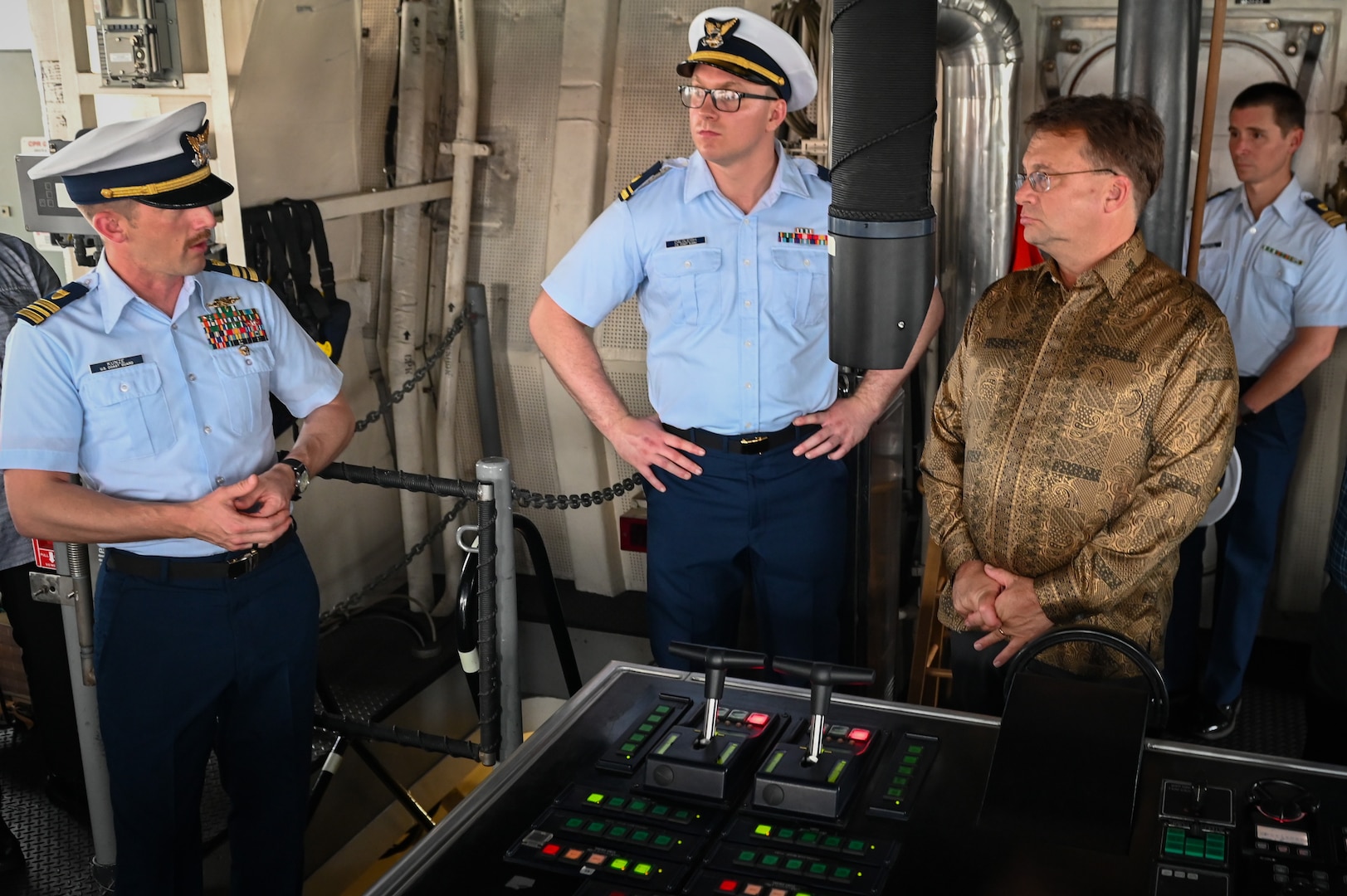 Lt. Cmdr. Philipp Kunze, operations officer aboard U.S. Coast Guard Cutter Bertholf (WMSL 750), speaks to Edgard D. Kagan, U.S. Ambassador-designate to Malaysia, about the helm controls of the Bertholf during a tour while the cutter was moored at Port Klang, Malaysia, March 2, 2024. The Bertholf is a National Security Cutter homeported in Alameda, Calif. (U.S. Coast Guard photo by Petty Officer Steve Strohmaier)