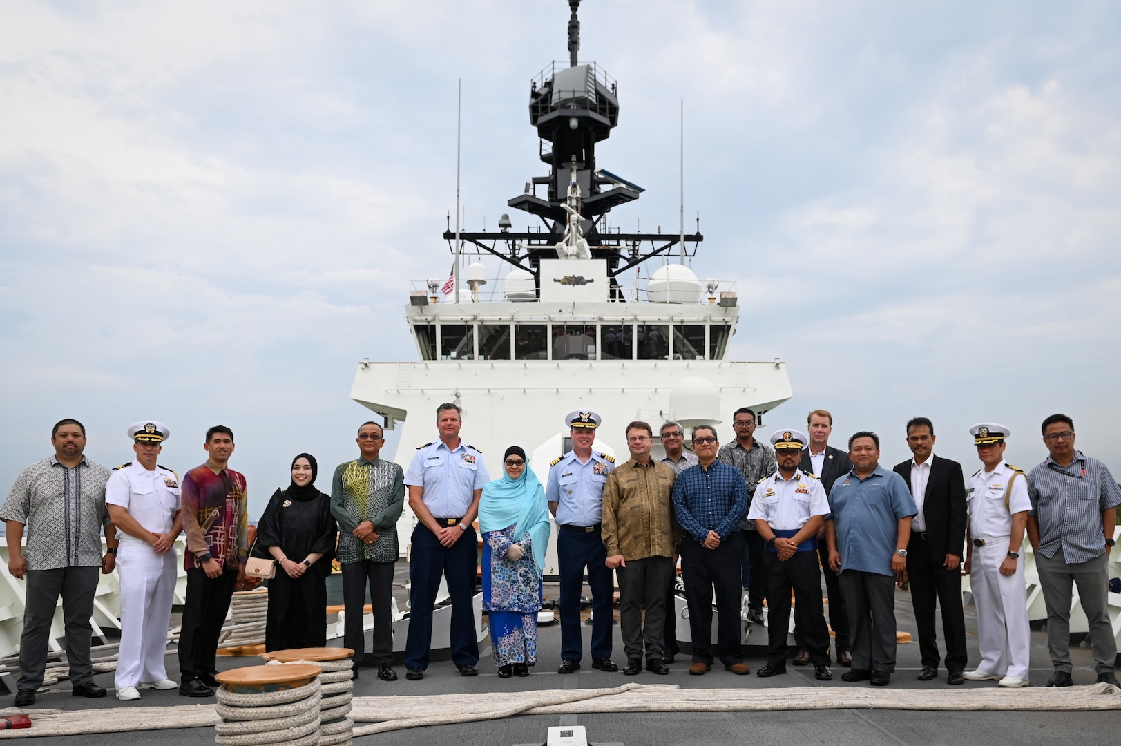 Dignitaries from multiple Malaysian government agencies, as well as members of the U.S. Navy and U.S. Coast Guard, pose for a photo at the bow of U.S. Coast Guard Cutter Bertholf (WMSL 750), while the cutter made a port call in Port Klang, Malaysia, March 2, 2024. This marked the first time a U.S. Coast Guard vessel called on Port Klang for a visit. (U.S. Coast Guard photo by Petty Officer Steve Strohmaier)
