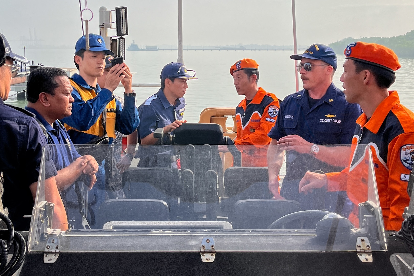 Members from the Japan Coast Guard stand aboard a small boat and listen to Chief Warrant Officer Casey Wardynski, first lieutenant aboard U.S. Coast Guard Cutter Bertholf (WMSL 750), while the cutter was moored in Port Klang, Malaysia, March 3, 2024. These engagements provided a training and best-practices opportunities for Japan Coast Guard and U.S. Coast Guard members. (U.S. Coast Guard photo by Ens. Tyler Ma)