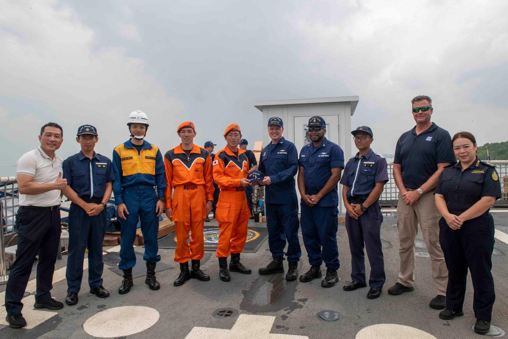 Members of the Japanese Coast Guard accept a gift from U.S. Coast Guard Capt. Billy Mees, commanding officer of U.S. Coast Guard Cutter Bertholf (WMSL 750), March 3. Bertholf was in Malaysia for a multiple day engagement which directly supports U.S. foreign policy and national security objectives in the Indo-Pacific Strategy and the National Security Strategy. (U.S. Navy photo taken by Mass Communication Specialist 3rd Class Charlotte Duran)