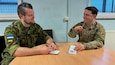 Veebel Kaur Jars, a training non-commissioned officer with the 61st Combat Support Services, 1st Infantry Brigade of the Estonian Defense Forces (left), and Staff Sgt. Joseph Nuttall, a civil affairs sergeant with the 353rd Civil Affairs Command (right) discuss similarities between civil affairs (CA) and civil-military cooperation (CIMIC) during exercise Austere Challenge 24 here on March 13, 2024. Exercise Austere Challenge 24, a command post exercise (CPX) focused on training combatant command coordination, U.S. interagency, and integration amongst the U.S., NATO, Allies, and partners in planning across multiple domains.