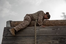 U.S. Marine Corps Recruit Lesile Serna, with Charlie Company, 1st Recruit Training Battalion, climbs over a wall during a confidence course training event at Marine Corps Recruit Depot San Diego, California, March 11, 2024. The confidence course is designed to challenge recruits physically and mentally through the execution of obstacles that require strength, balance, and determination. (U.S. Marine Corps photo by Cpl. Sarah M. Grawcock)