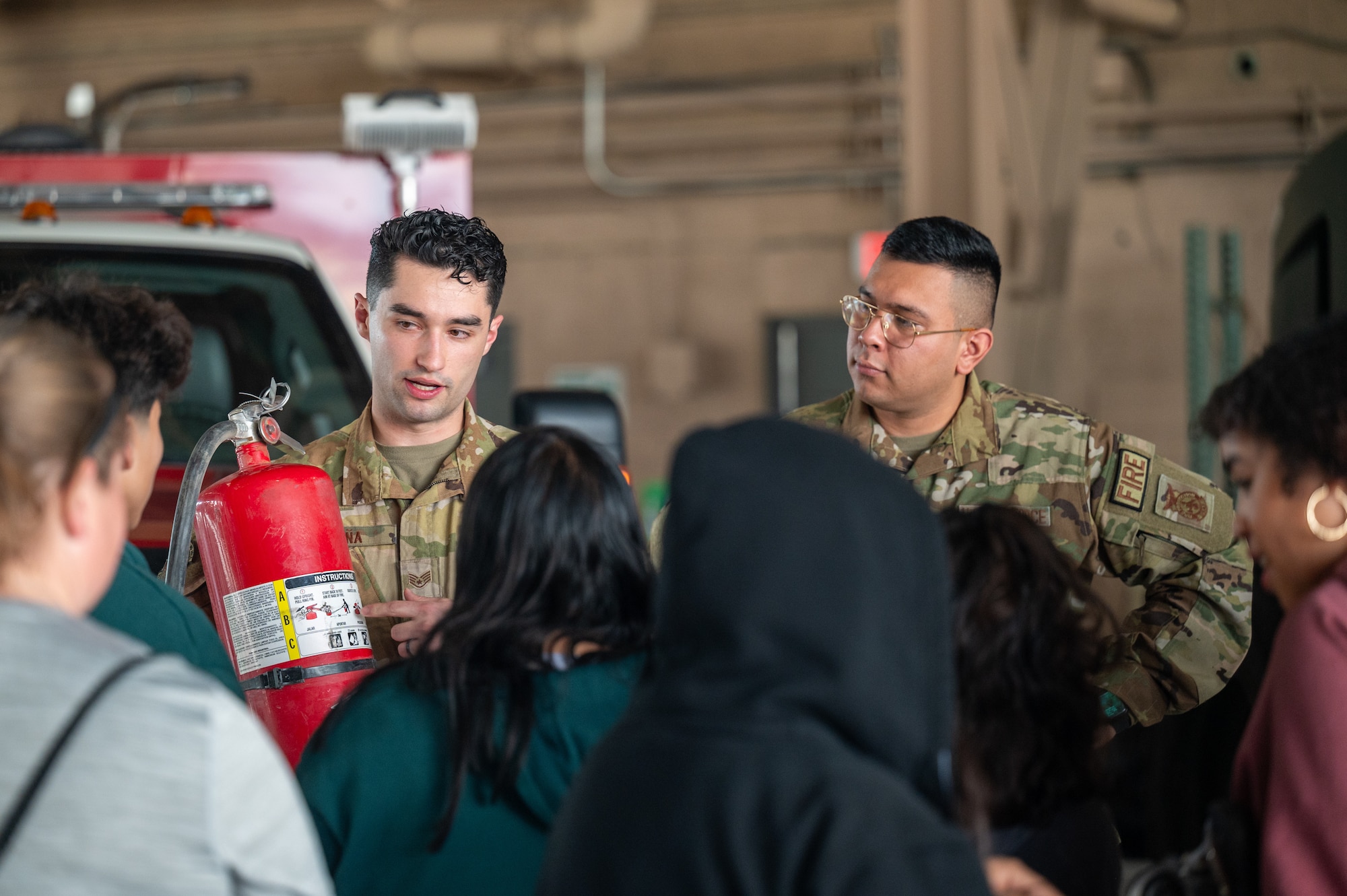 U.S. Air Force Staff Sgt. Jared Peña and Senior Airman Alvaro Machuca, 99th Civil Engineer Squadron Fire Specialists, speaks with students about fire safety on Nellis Air Force Base, Nevada, Feb. 26, 2024.