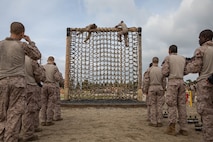 U.S. Marine Corps recruits with Charlie Company, 1st Recruit Training Battalion, climb over an obstacle during a confidence course training event at Marine Corps Recruit Depot San Diego, California, March 11, 2024.  The confidence course is designed to challenge recruits physically and mentally through the execution of obstacles that require strength, balance, and determination. (U.S. Marine Corps photo by Cpl. Sarah M. Grawcock)