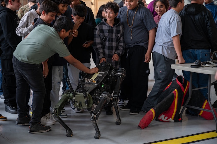 U.S. Air Force Tech Sgt. Halligan Matthew, 99th Security Forces Squadron, introduces students to the Vision 60 “Robot Dog” on Nellis Air Force Base, Nevada, Feb. 26, 2024.