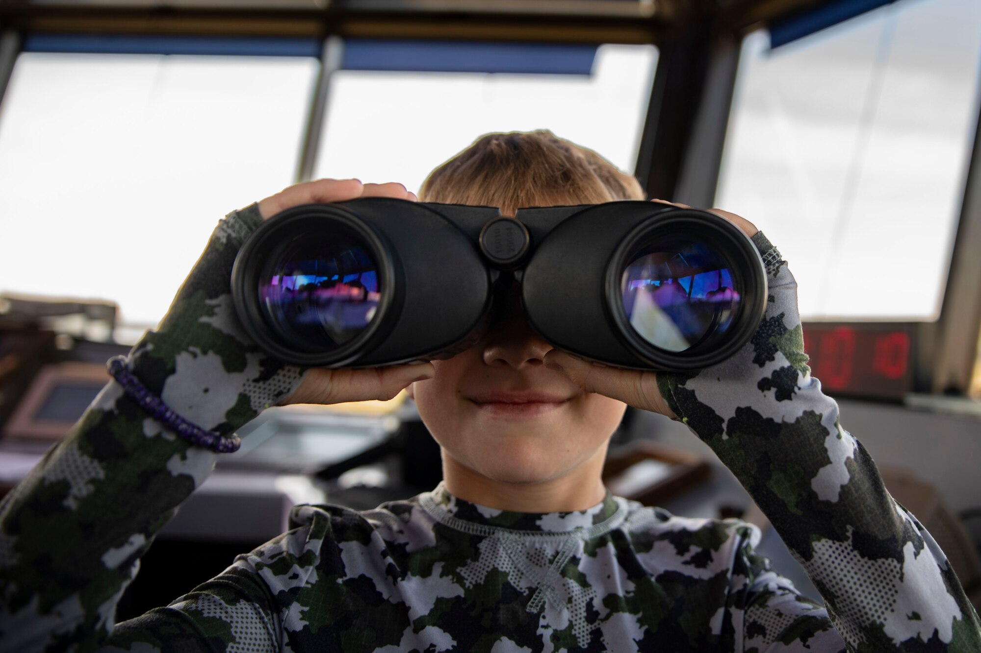 A child holds binoculars to their face