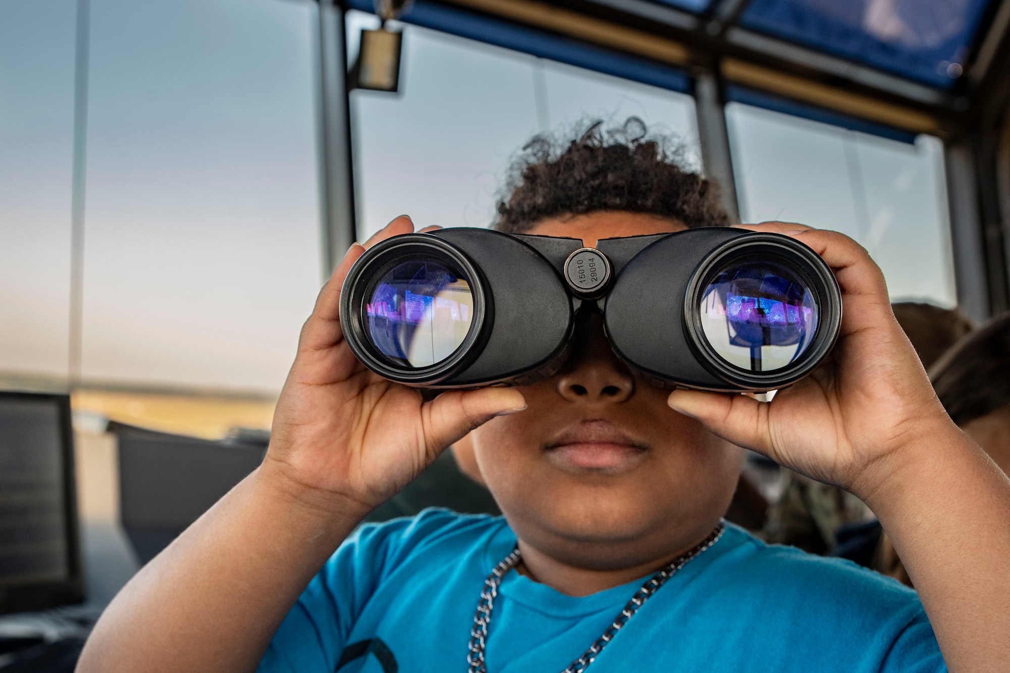 A child holds binoculars to his face