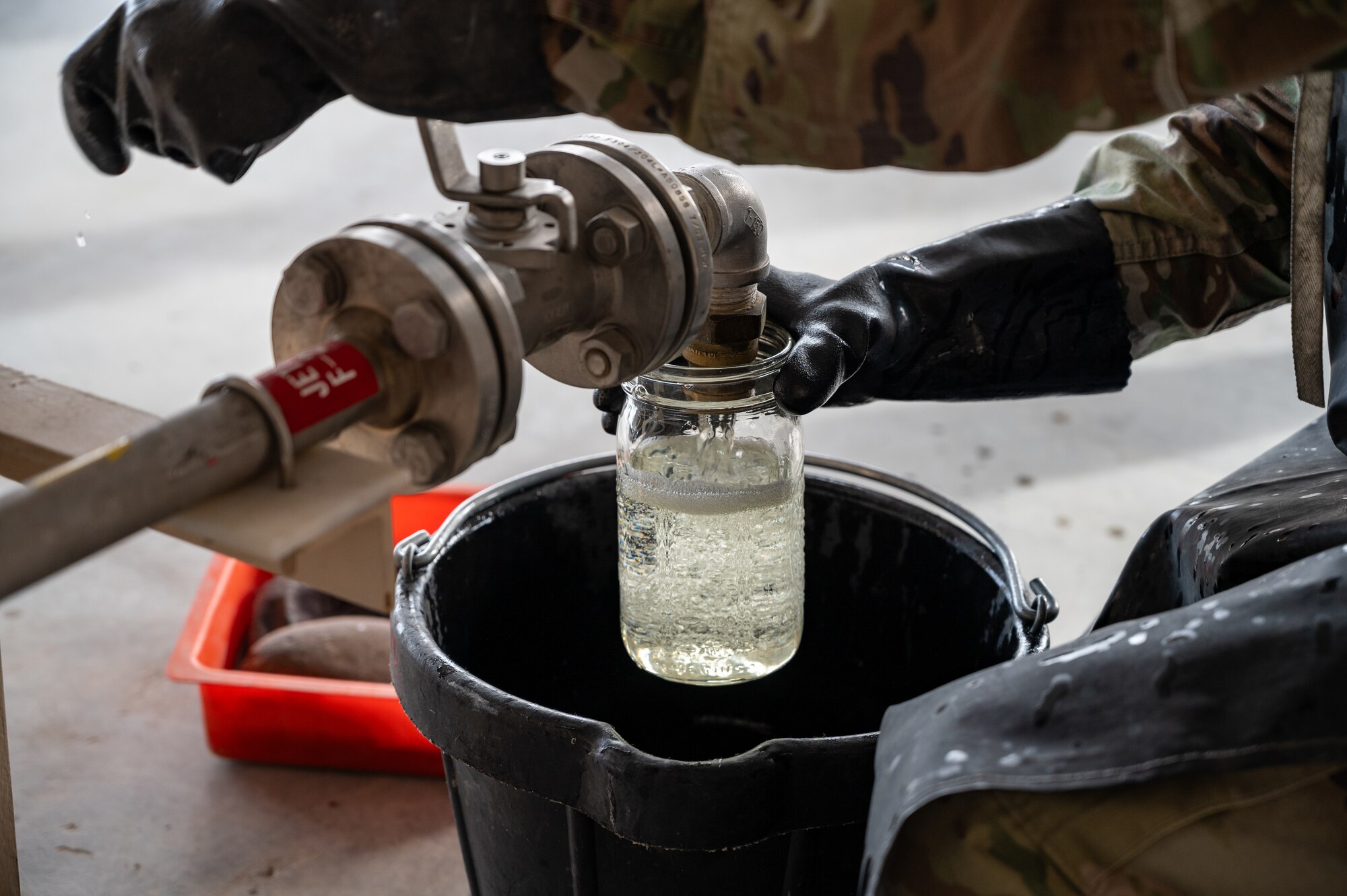 U.S. Air Force Staff Sgt. Glen Foster, a Fuels Facilities Supervisor assigned to the 99th Logistics Readiness Squadron, drains a filter sump at Nellis Air Force Base, Nevada, March 11, 2024.