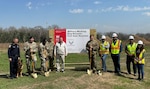 People with shovels at a construction site, and a dog.