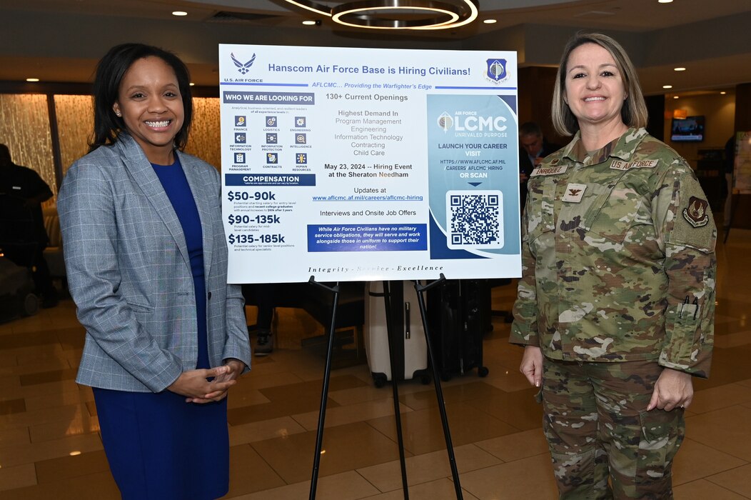 Image of two people standing next to sign.