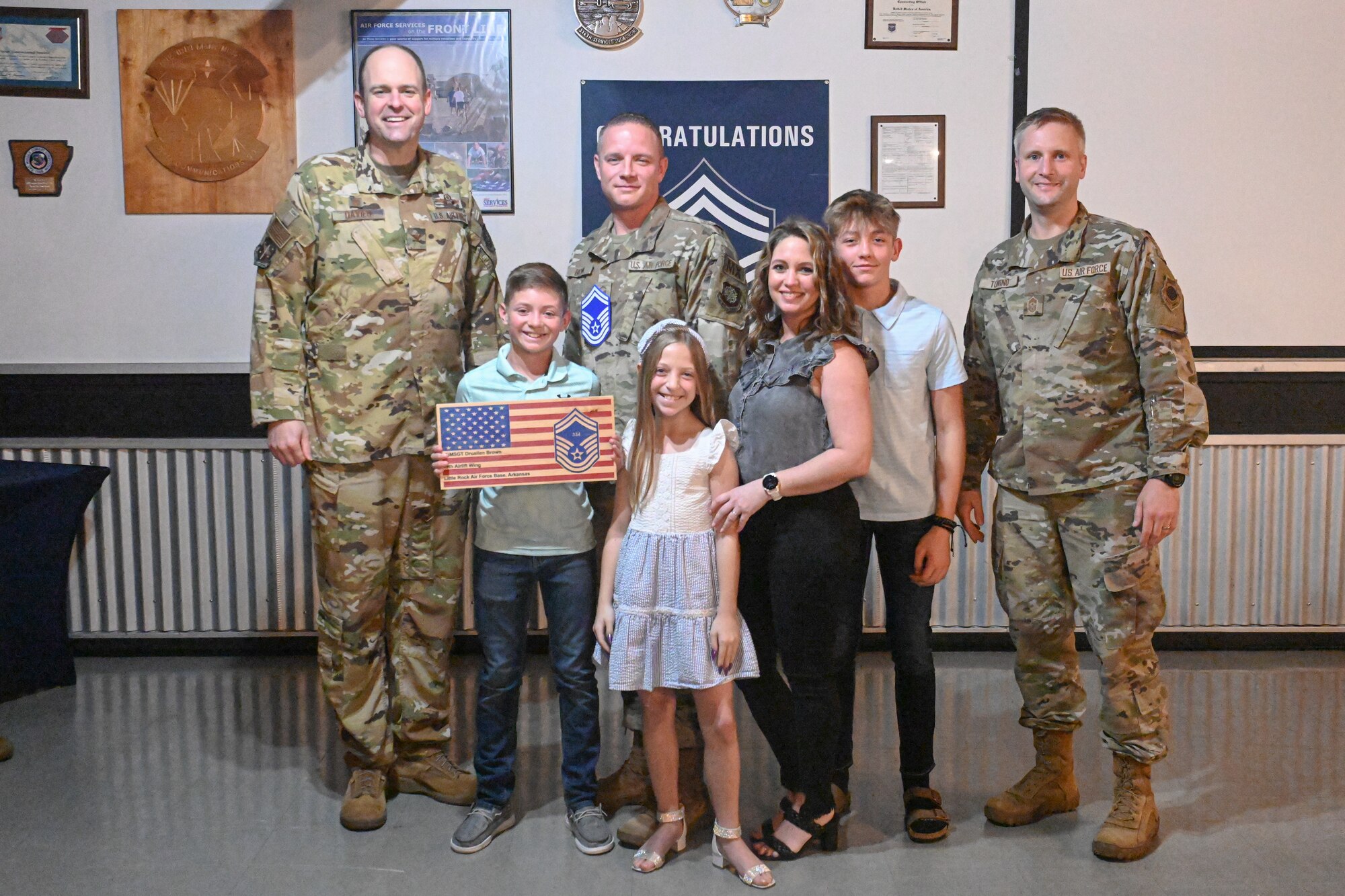 Men in uniform and family pose for a photo.