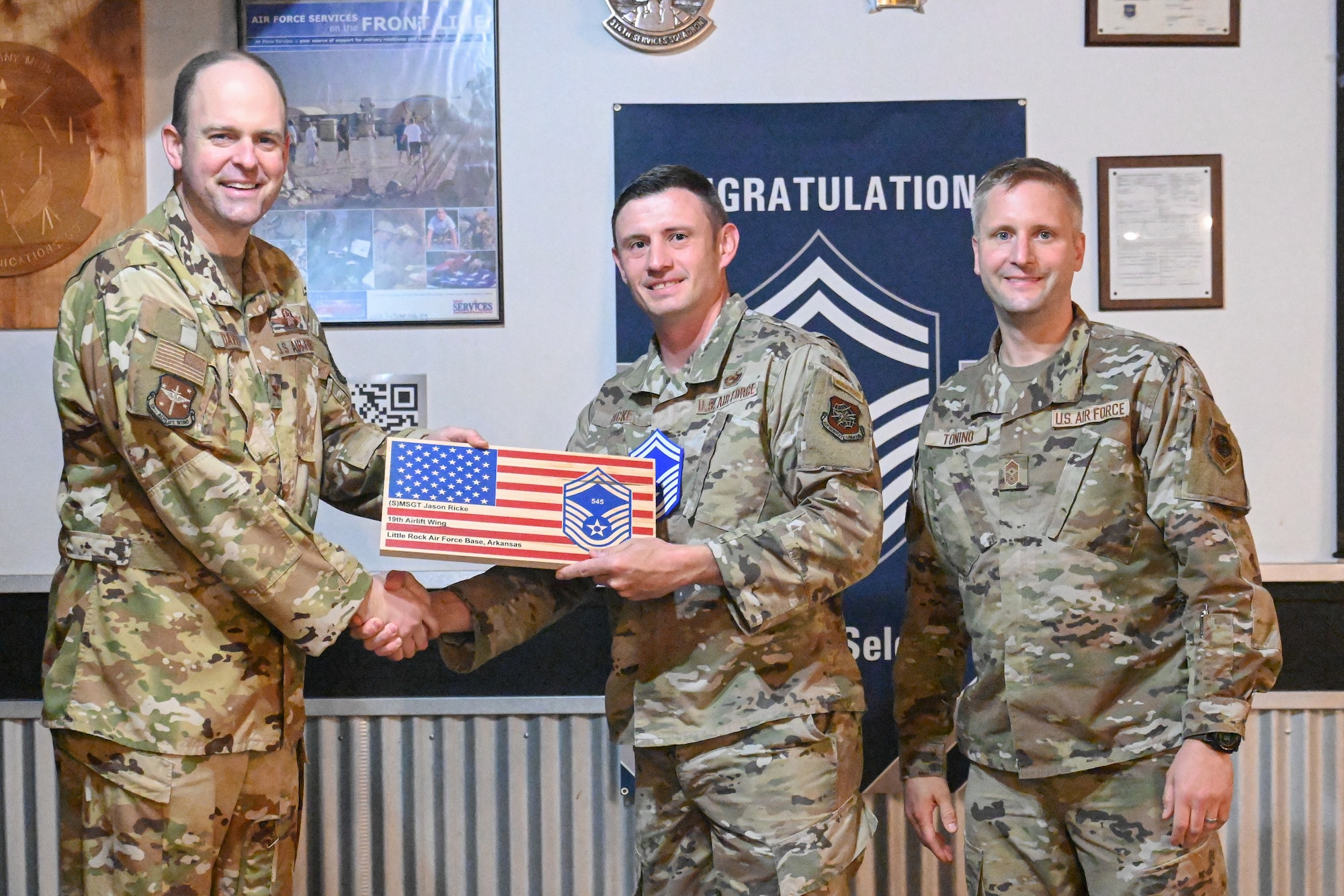 Men in uniform pose for a photo.