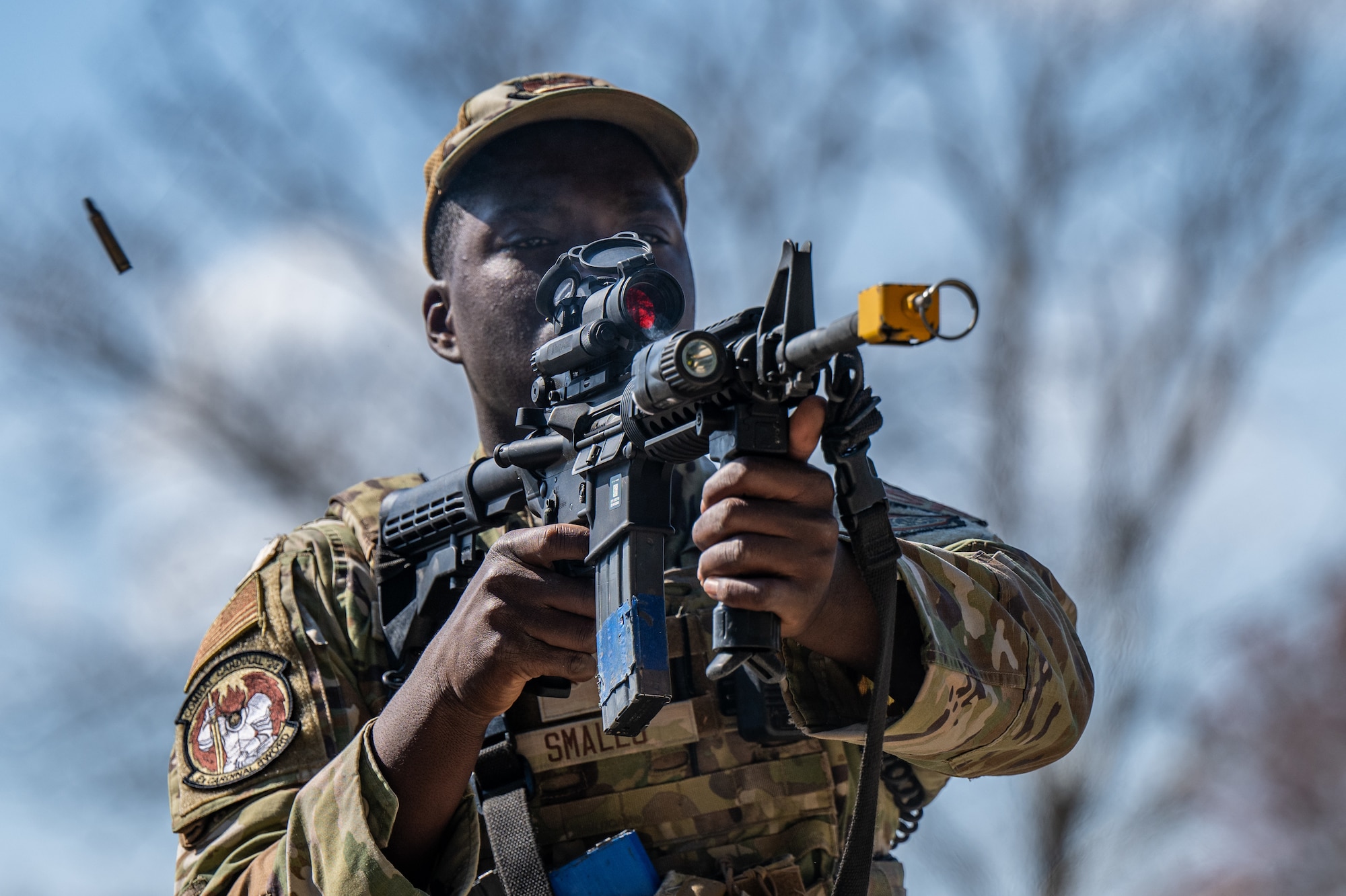 An Airman fires their weapon with blank rounds.