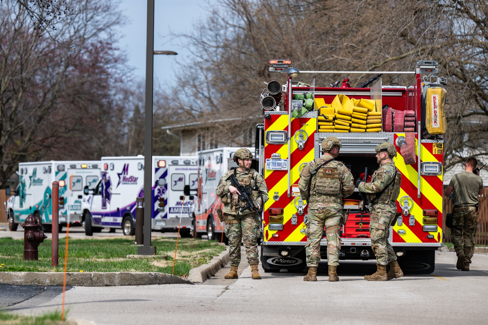 Airmen stand around a fire truck