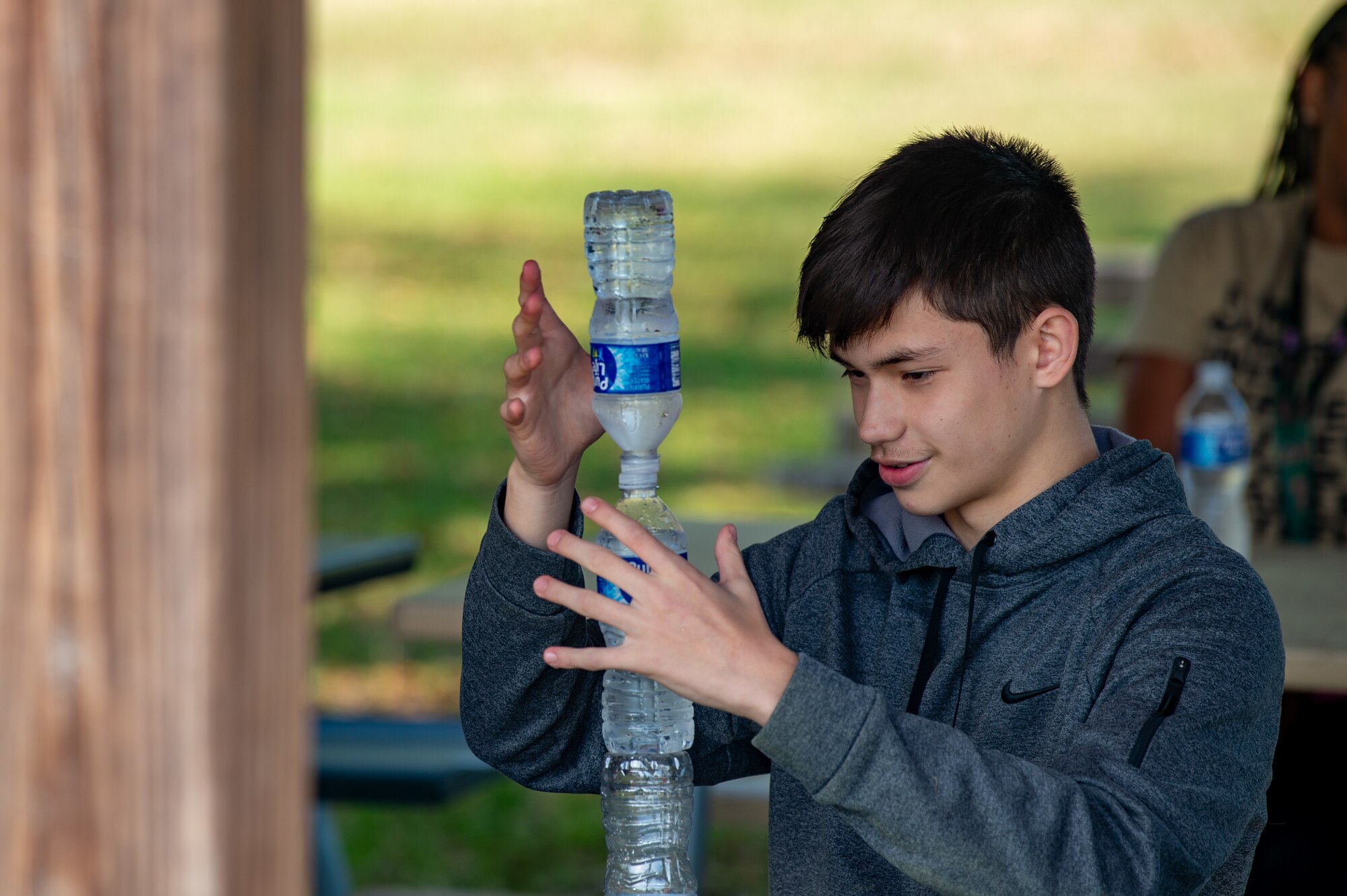 A Pine Grove Middle School student stacks three water bottles as a bet from a peer at Moody Air Force Base, Georgia, March 14, 2024. As part of Women in Aviation, Moody AFB held a luncheon for Airmen and their families. Team Moody’s annual WIA events aim to highlight aviation-related career fields and inspire local youth to consider futures in the Air Force. (U.S. Air Force photo by Airman 1st Class Iain Stanley)