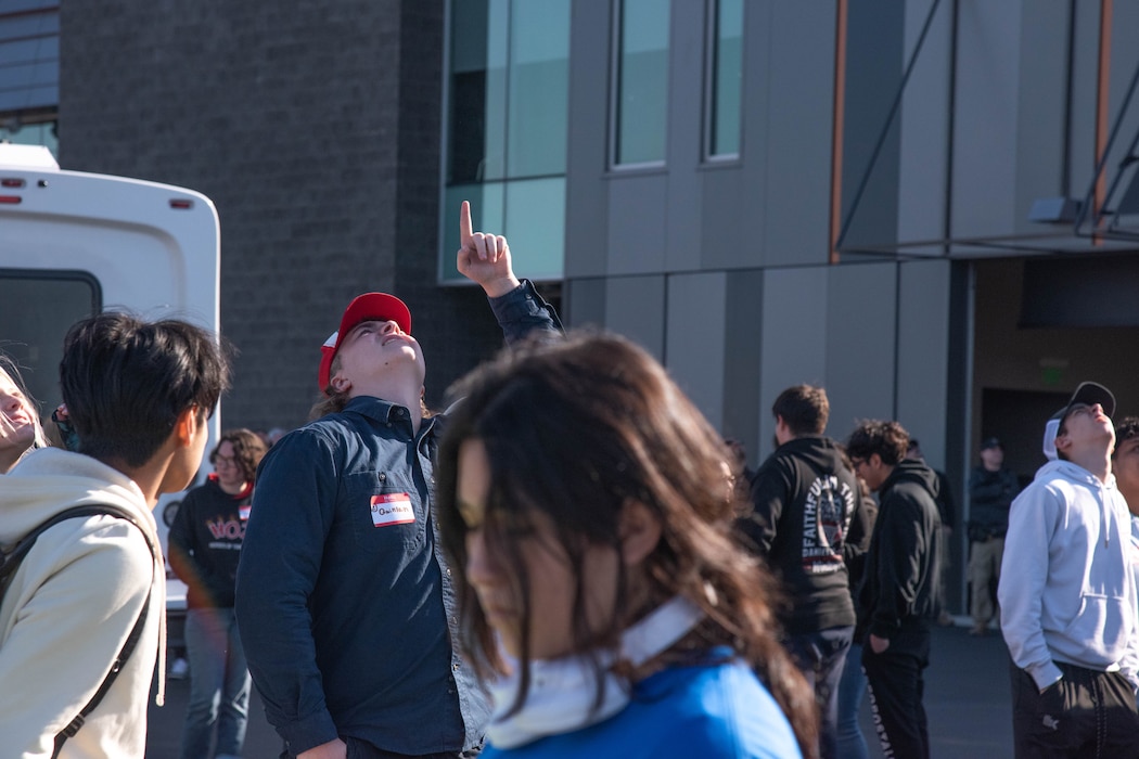 Students looking into sky, pointing.