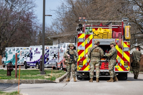 Airmen stand around a fire truck