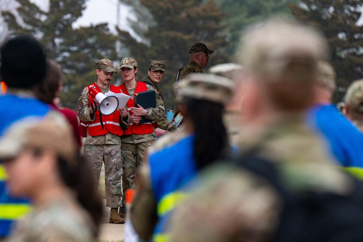 Airmen prepare to speak to a crowd before a simulated deployment.