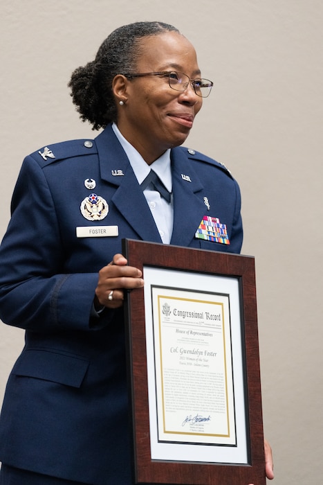 Image of an Airmen holding a plaque.