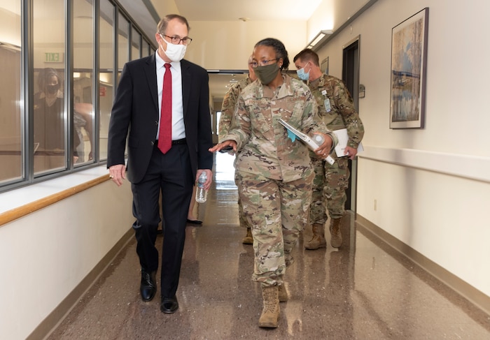 Image of two people walking in a hallway.