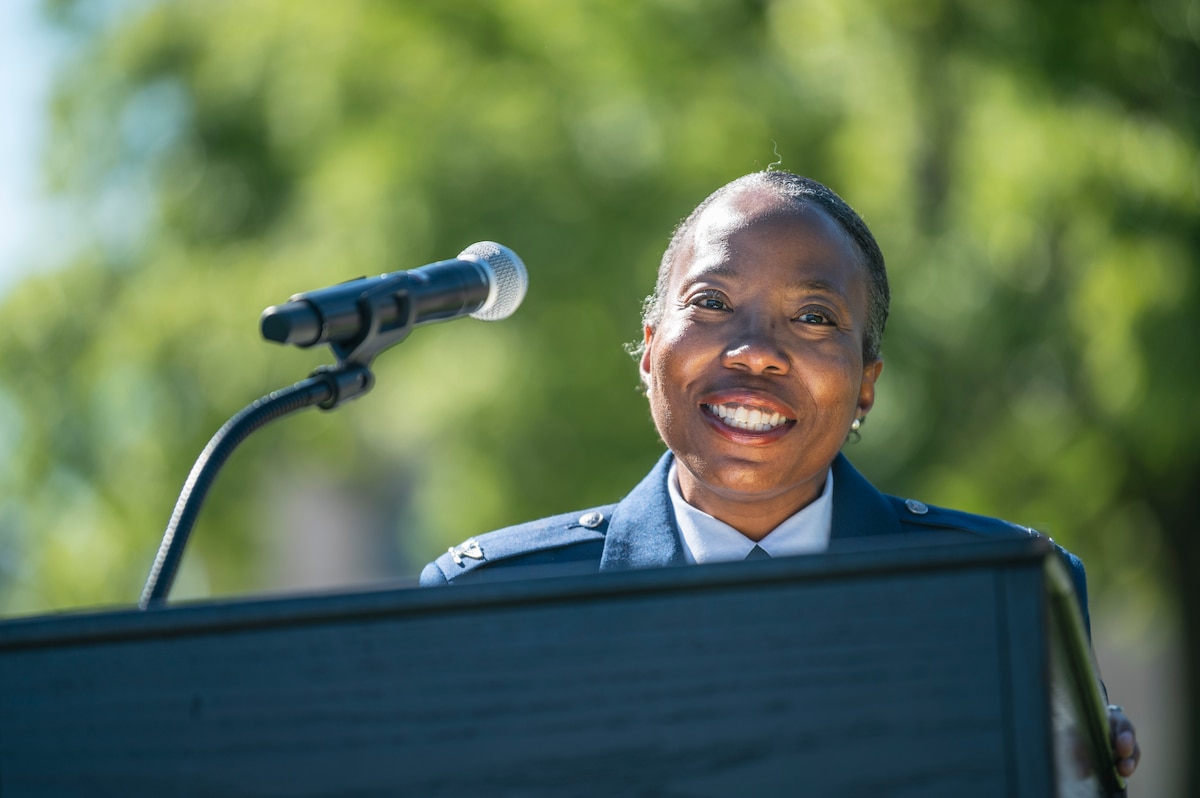 Image of an Airman speaking at a podium.