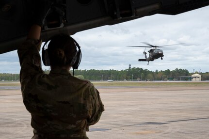 A U.S. Army UH-60 Black Hawk helicopter assigned to the 3rd Battalion, 238th Aviation Regiment General Support Aviation Battalion, Michigan Army National Guard, lands beside a U.S. Air Force C-130 Hercules aircraft assigned to the 186th Air Refueling Wing, Mississippi Air National Guard, in preparation for combat air medical operations training during Southern Strike 2024 at Gulfport Combat Readiness Training Center in Gulfport, Mississippi, March 13, 2024. The team participating in the training included the 146th Aeromedical Evacuation Group, 146th Airlift Wing, California Air National Guard; and the 114th Medical Group, 114th Fighter Wing, South Dakota Air National Guard.