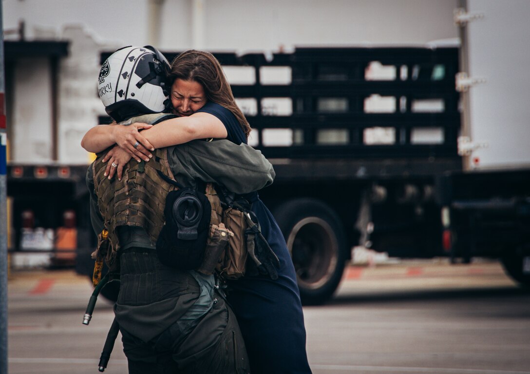 A U.S. Marine AV-8B Harrier pilot Maj. Brian Neri, assigned to Marine Attack Squadron 231 Detachment, Marine Medium Tiltrotor Squadron 162 (Reinforced), 26th Marine Expeditionary Unit (Special Operations Capable) reunites with his family after returning from deployment at Marine Corps Air Station Cherry Point, North Carolina, Mar. 16, 2024. Marines and Sailors assigned to the 26th MEU(SOC) returned home after completing an eight-month deployment embarked aboard the Bataan Amphibious Ready Group. During its deployment, the BAT ARG and 26th MEU(SOC) team participated in a wide array of exercises with NATO Allies and regional partners spanning across the Tri-Geographic Combatant Command to enhance interoperability, MAGTF readiness, and provide crisis response options. (U.S. Marine Corps Photo by Cpl. Aziza Kamuhanda)