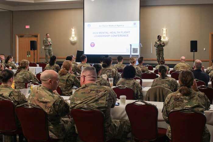 Image of service members speaking at a conference.