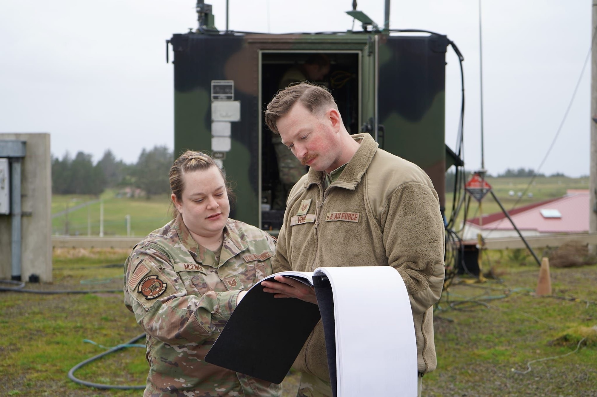 Tech. Sgt. Stacie McEwan (left) of the 116th Air Control Squadron reviews wiring diagrams with Tech. Sgt. Robert Vens of the 225th Support Squadron at Camp Rilea in Warrenton, Oregon this February. During this training, the 116th ACS demonstrated their ability to integrate the control and reporting center into the homeland defense design to the 225th and the Western Air Defense Sector.