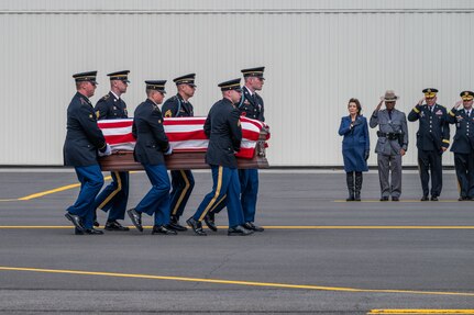A New York Army National Guard Honor Guard team carries the remains of Chief Warrant Officer 2 John M. Grassia III from a New York Air National Guard LC-130 to a hearse past a line of dignitaries, including Gov. Kathy Hochul, during plane-side honors at the Army Aviation Support Facility in Latham, New York, March 18, 2024. Grassia and Chief Warrant Officer 2 Casey Frankoski were killed in a March 8 helicopter crash in Texas.