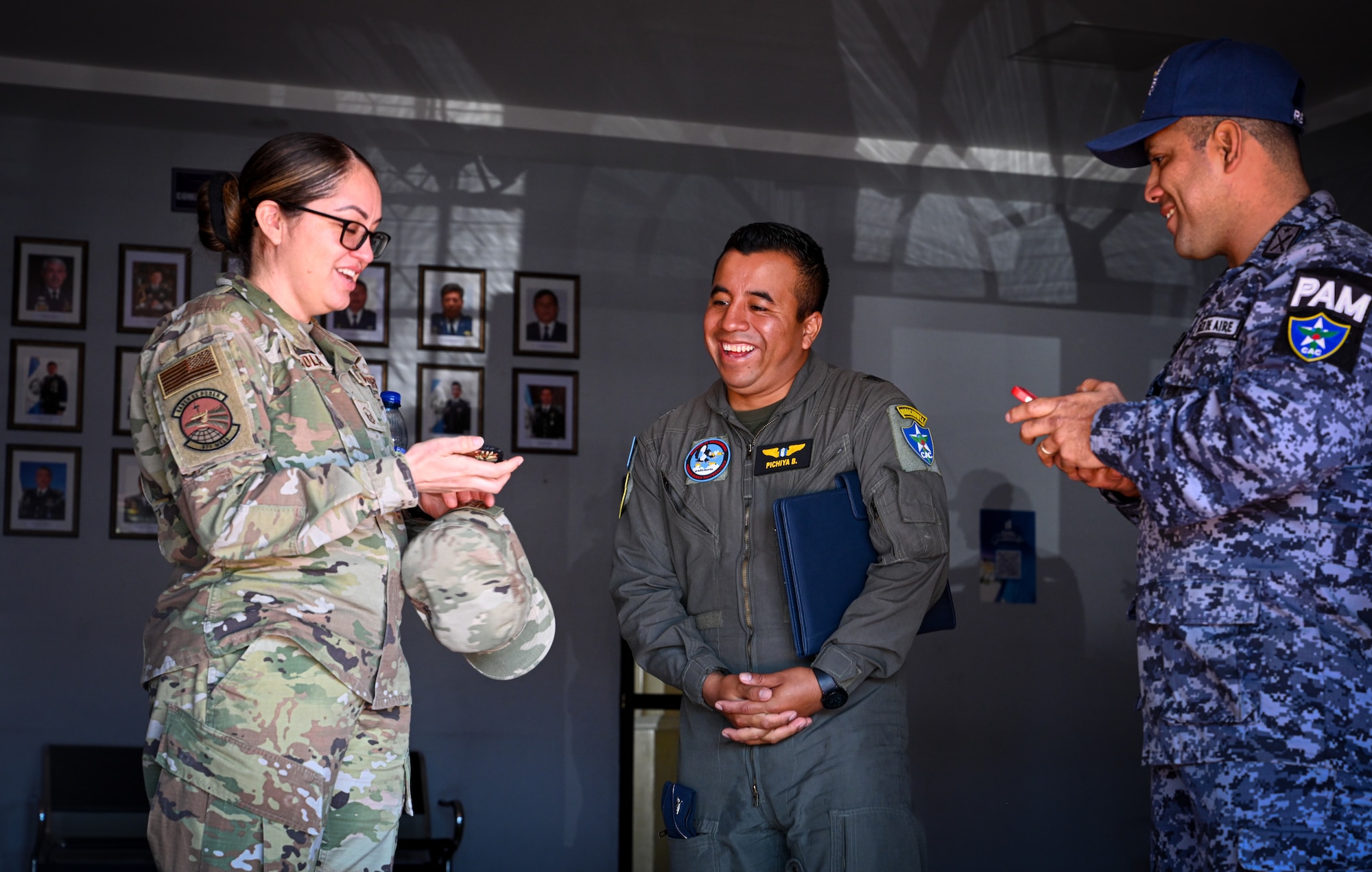 U.S. Air Force Master Sgt. Ana Mendiola, left, a 571st Mobility Support Squadron training flight chief, spoke to Oficial De Inteligencia del Comando Aéreo Central (CACEN), Cápitan Juan J. Pachiya Barrios, middle, and Cápitan 2do. De Infantería Erlin Omar Reyna De Leon, right, about similarities between the two Air Force units at CACEN “La Aurora” in Guatemala City, Guatemala, Feb. 20, 2024.