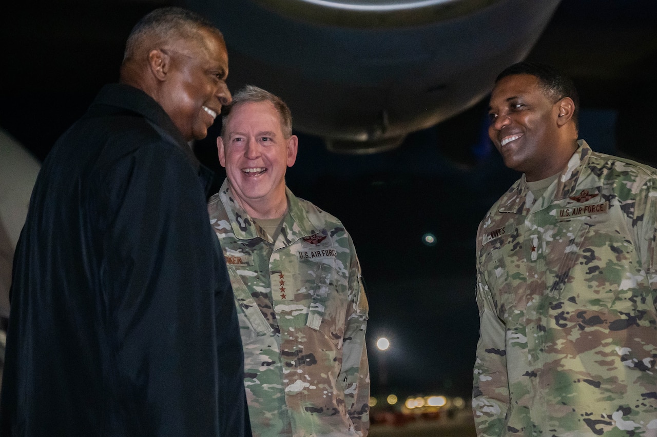 Three people speak. Two .e men are wearing military uniforms.