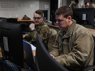 Staff Sgt. Dawston Regan, left, and Tech. Sgt. Thomas Monroe, cyberspace operators from the 168th Cyberspace Operations Squadron, Iowa Air National Guard, prep their stations during an exercise Feb. 29, 2024, at the 132d Wing in Des Moines, Iowa. The exercise was the first by the 132d Wing’s new cyber range.