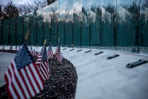 miniature U.S. flags are seen in front of the war memorial