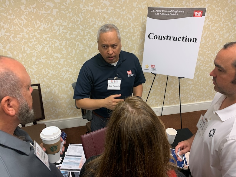 Richard Fontanilla, an area engineer with the U.S. Army Corps of Engineers Los Angeles District, center, speaks with participants during the Business Opportunities Open House March 13 at the Midtown Hilton Garden Inn in Phoenix. Fontanilla is a professional engineer with more than 29 years of experience.
